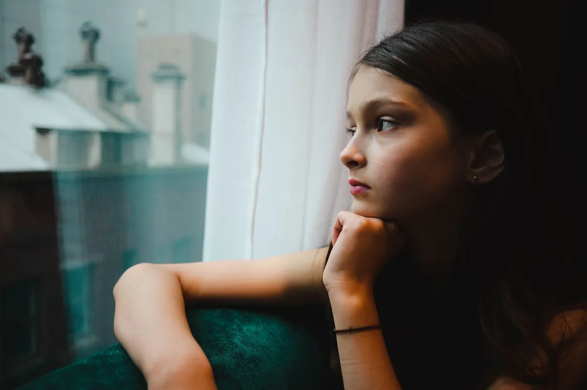 sad girl looking out window