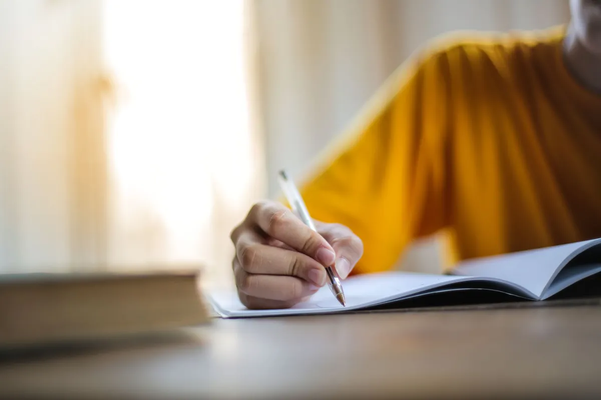 person writing in notebook
