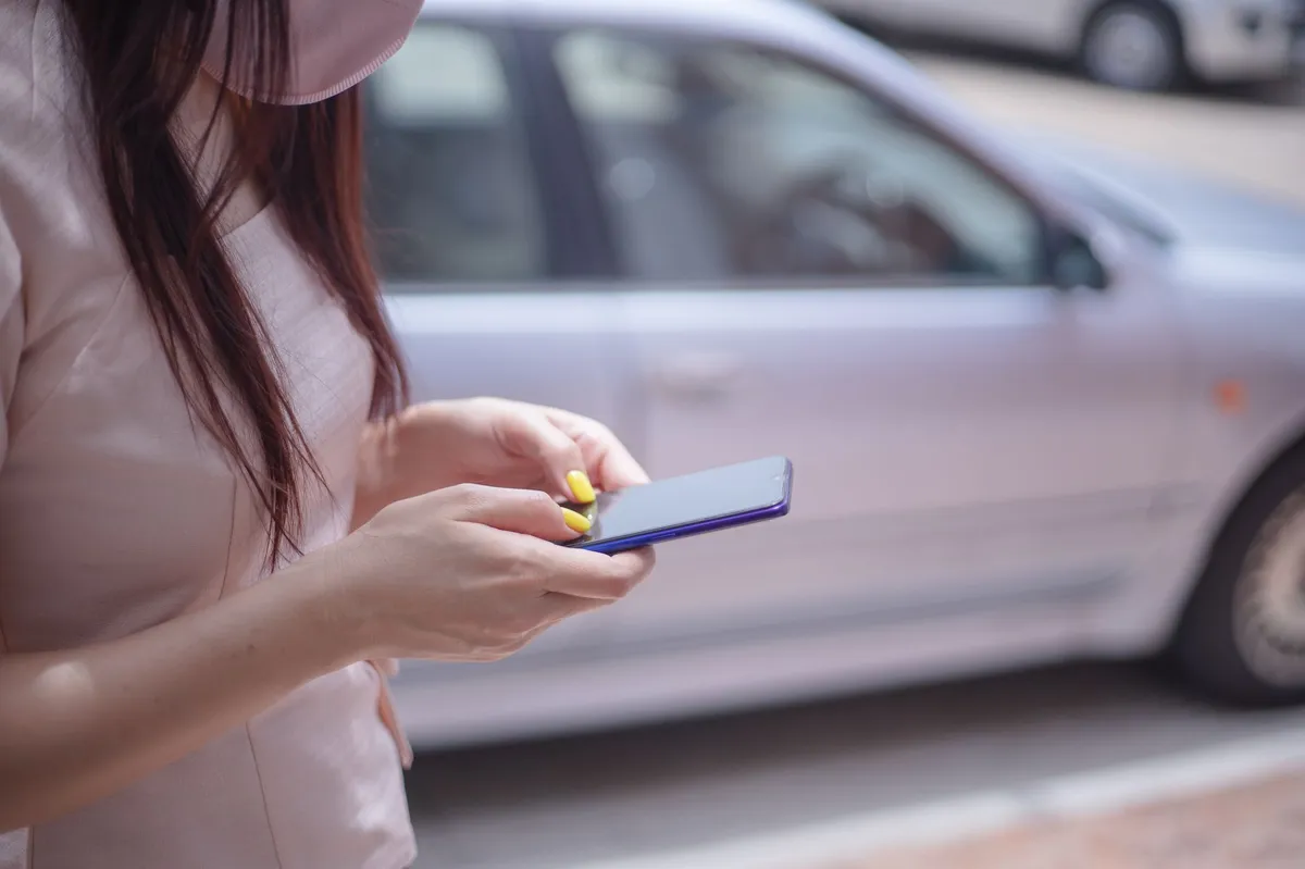 person using smartphone in car